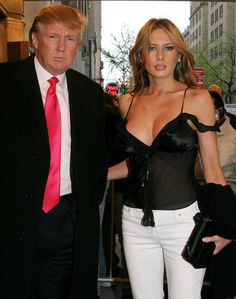 a woman in a corset walking next to a man wearing a suit and tie