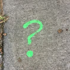 a sidewalk with a green question mark painted on it