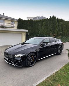 a black car parked in front of a house