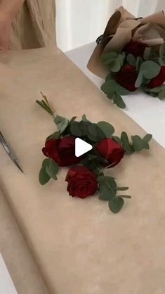 someone is cutting roses on a table with scissors