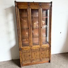 an old china cabinet with glass doors and bamboo trimmings on the bottom shelf