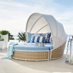 an outdoor bed with blue and white pillows