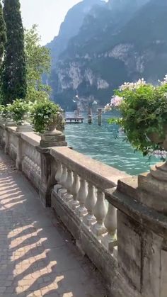 the walkway is lined with potted plants and stone railings, along with mountains in the background