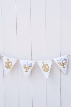 a white and gold hanukkah banner hanging from a string on a wall