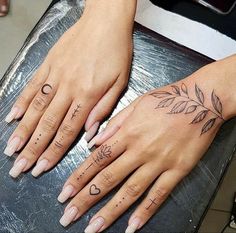 two hands with tattoos on them sitting next to each other and one has the word love written in cursive writing