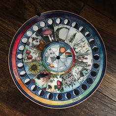 a colorful plate on a wooden table with mushrooms and other things painted on the surface