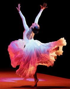 a ballerina in white and pink dress on stage