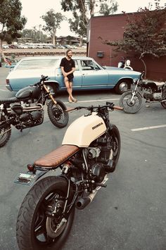 a person sitting on a motorcycle in a parking lot