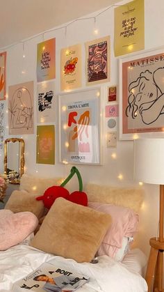 a bed with lots of pillows and pictures on the wall next to it's headboard