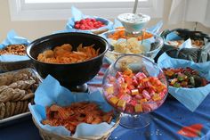 a table topped with bowls filled with different types of snacks and desserts next to each other