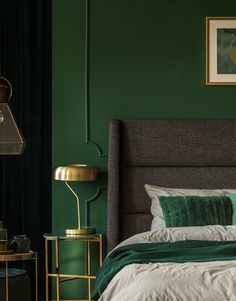 a bedroom with green walls and gold accents