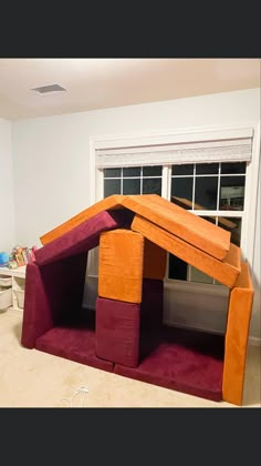 a dog house made out of cardboard in the middle of a living room