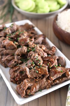 a white plate topped with meat covered in sauce and garnished with parsley