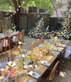 an outdoor dining area with tables and chairs set up for a formal dinner in the garden