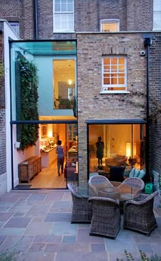 an outdoor patio with wicker furniture and large windows