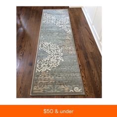 the rug is on the wooden floor and it has an orange border around it that says $ 50 & under