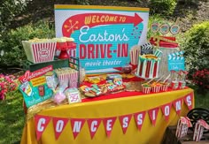 an outdoor movie themed birthday party with popcorn, candy and moviesigns on the table