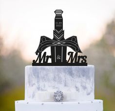 a wedding cake with an artistic topper