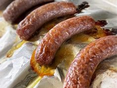 four sausages are sitting on tin foil