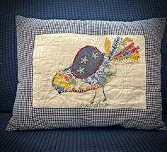 a pillow with a bird on it sitting on a couch