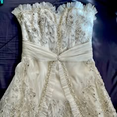 the back of a white dress with beading on it