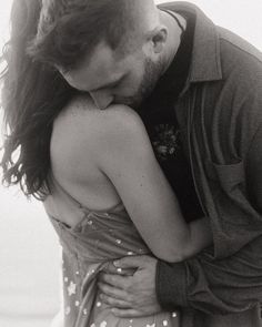 a man and woman embracing each other on the beach