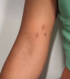 a woman's arm with three small stars on the left side of her arm