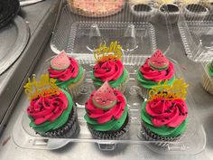 cupcakes decorated with watermelon and strawberries are displayed in plastic trays