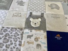 a quilted baby blanket with animals and letters on it's sides, including a teddy bear