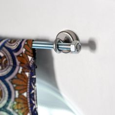 a tie hanging on the side of a white wall next to a metal door handle