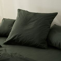 a bed with green sheets and pillows on it