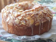 a bundt cake sitting on top of a plate covered in frosting and nuts