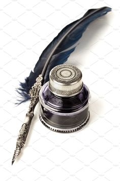 a feather quill and inkwell on a white background