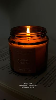 a candle that is sitting on top of a book with the words floral passion written in it