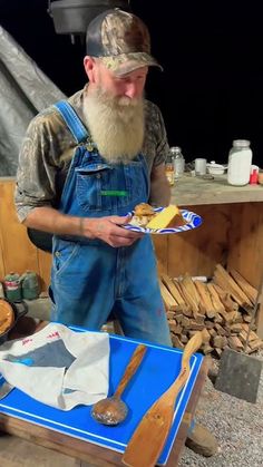 a man in overalls holding a plate with bread on it next to other items