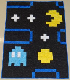 a black quilt with yellow and blue squares on it