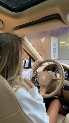 a woman sitting in the driver's seat of a car