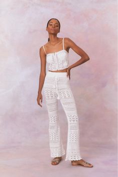 White cotton pointelle crochet floral flare pants with a self tie detail at center front on the double ribbed waistband. White Lace Trim Bottoms For Festival, Spring Cotton Bottoms With Crochet Lace, Spring Cotton Crochet Lace Bottoms, White Bohemian Bottoms With Crochet Trim, White Crochet Lace Bottoms For Vacation, Bohemian Crochet Lace Bottoms For Festival, Casual Cotton Bottoms With Crochet Lace, White Bohemian Bottoms With Lace Trim, White Crochet Lace Casual Bottoms