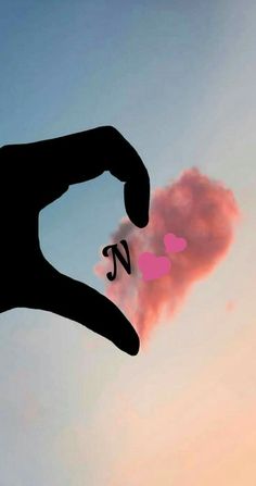 a person holding out their hand with the letter n in front of a pink cloud