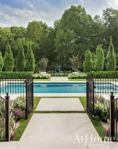 an outdoor swimming pool surrounded by trees and flowers