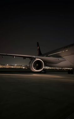 an airplane is sitting on the runway at night