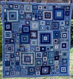 two quilts are hanging on the clothesline and one is made with blue squares