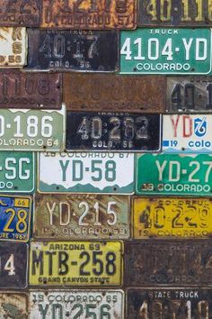 many different license plates are stacked on top of each other in this image, the colors and numbers appear to be rusted