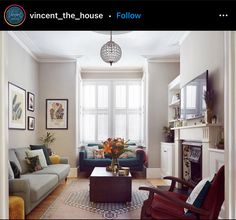 a living room with couches, chairs and a fire place in the center area