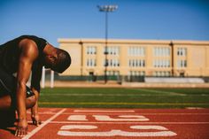 a man kneeling down on a running track