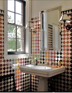 a bathroom with checkered walls and a sink in the middle, next to a window