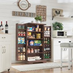 a kitchen filled with lots of food and drinks on top of a wooden cabinet next to a counter