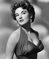 an old black and white photo of a woman in a halter top with large hoop earrings