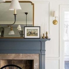 a living room filled with furniture and a fire place under a large mirror on top of a mantle