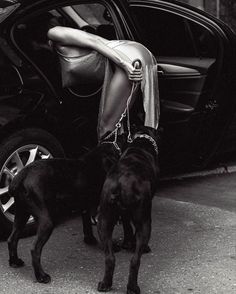 a woman leaning on the door of a car with her dog